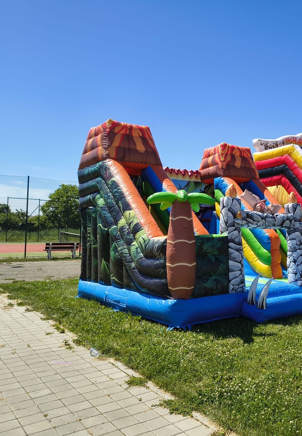 Skákací hrad Sopka s dinosaury, palmami a dvěma skluzavkami
